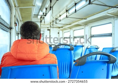 Empty train interior with lone passenger figure. Illustrates demographic shift in transit usage, remote work infrastructure impact, flexible schedule normalization, and post-density urban patterns.
