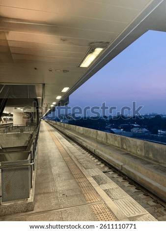 Empty train platform at dusk. Modern architecture, leading lines, urban transport. Evening sky, cityscape view. Travel and infrastructure concept.
