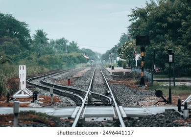 Empty train track, metal railway with rail switching and signboard pole at station in countryside - Powered by Shutterstock