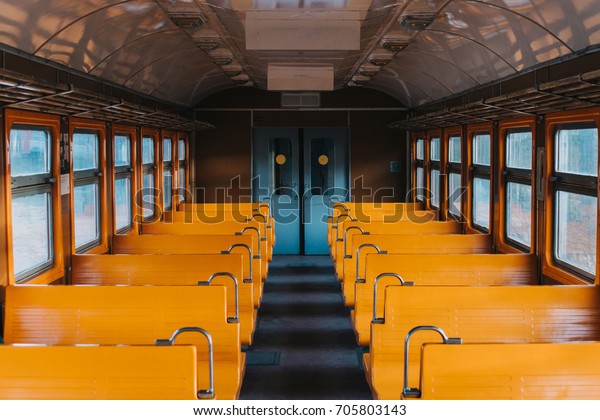 Empty train wagon with yellow seat seats\
without passengers, Russian commuter\
train