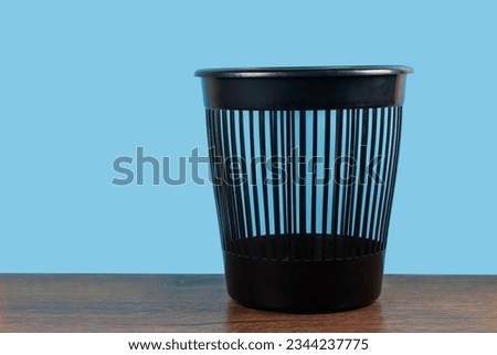 Empty trash, clean garbage bin, plastic basket bin on blue background.