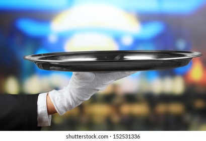 Empty tray in hand waiter on restaurant background