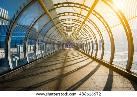Empty tunnel with footpath lit by sunset