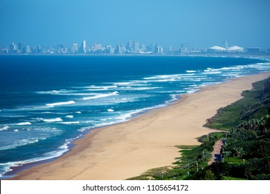 Empty Umhlanga beach shoreline ocean and waves against blue sky City skyline coastal landscape in Durban, South Africa.