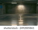 Empty underground garage. Parking lot with overhead dim light