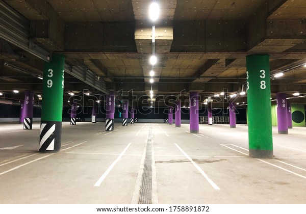 empty underground parking lot with colorful columns on\
basement of shopping mall. No cars, no people due to non-working\
store hours. 