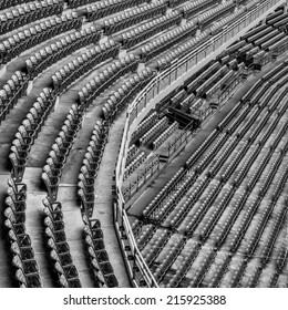 An empty upper and lower deck of an old stadium in black and white
