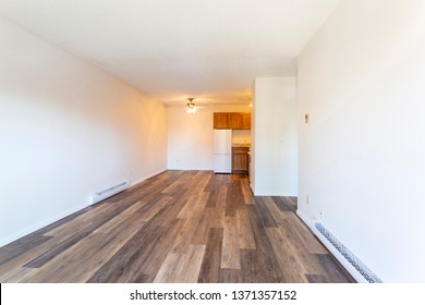 An empty vacant rental apartment property with new hardwood laminate floors and white paint on the walls.