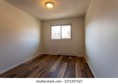 An empty vacant rental apartment property with new hardwood laminate floors and white paint on the walls.