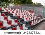 Empty vacant small stadium seats outdoors, bleachers, nobody, no people, cancelled sports event, nobody present at a sport show simple abstract concept. Chair rows up close, copy space, side view