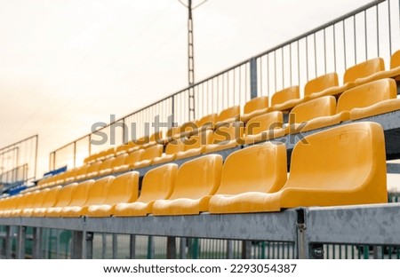 Empty vacant small stadium seats outdoors, bleachers, nobody, no people, cancelled sports event, nobody present at a sport show simple abstract concept. Chair rows up close, copy space, side view