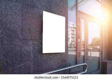 Empty vertically poster fixed on building wall near glass door entrance to office room or lawyer chamber