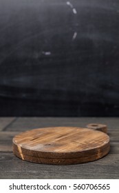 Empty vintage cutting board on dark wooden planks food background concept