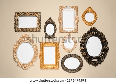 Empty vintage frames hanging on beige wall