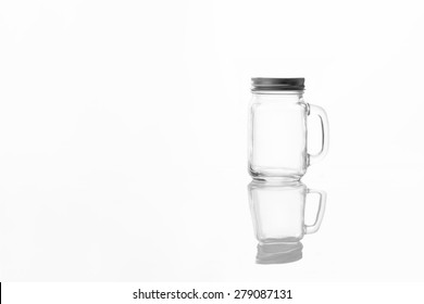 Empty Vintage Mason Jar  Having Lid And Handle With On White Background With Reflection And Copy Space