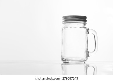 Empty Vintage Mason Jar  Having Lid And Handle With On White Background With Reflection And Copy Space