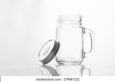 Empty Vintage Mason Jar  Having Lid And Handle With On White Background With Reflection And Copy Space