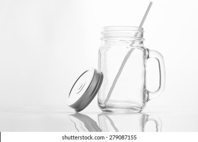 Empty Vintage Mason Jar  Having Lid And Handle With Straw On White Background With Reflection And Copy Space