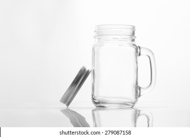 Empty Vintage Mason Jar  Having Lid And Handle With On White Background With Reflection And Copy Space