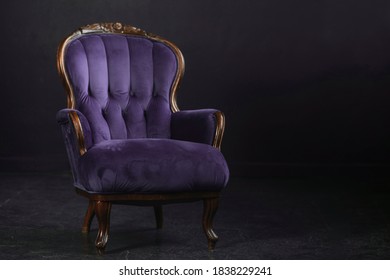 Empty Vintage Royal Purple Armchair Against Black Background
