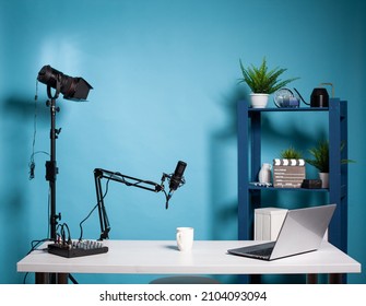 Empty vlog studio broadcasting room with professional microphone and video light used for recording social media content. Vlogging setup with digital mixer console and laptop computer. - Shutterstock ID 2104093094