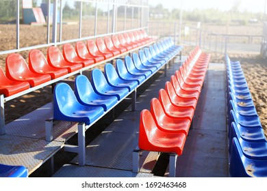 Empty Volleyball Court At The City Beach. Nobody Is On The Summer Beach Due To Quarantine Infection. Outdoor Sports Competition. Close Up View Of Plastic Chairs On The Stadium Bench.