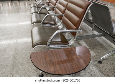 Empty waiting area of ​​the terminal of the international airport in Moscow, Russia. The design is austere and modern. The rows of chairs are dark brown with silver legs. There's no one in the lobby