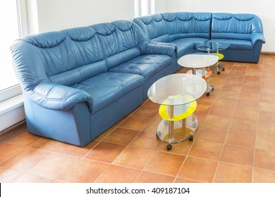Empty waiting room with a big blue sofa and two small tables. - Shutterstock ID 409187104