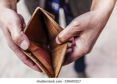 Empty wallet in the hands of an elderly man. 