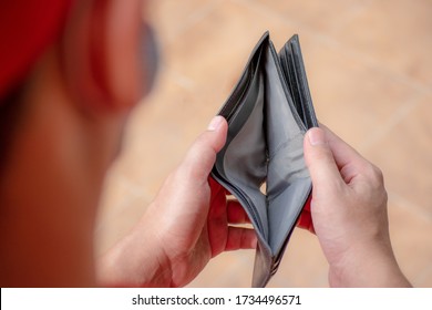 Empty Wallet (no Money) In The Hands Of An Man. A Man No Have Money Unemployed And Bankrupt Looks Into His Empty Wallet. Unemployed Businessmen Are Waiting For New Jobs. Stress From Covid-19 Crisis,