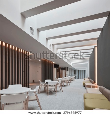 Empty warehouse interior with high ceiling, exposed services, concrete structure, and organized industrial space.