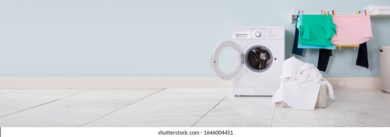 Empty Washing Machine With Pile Of Dirty Cloth In The Basket At Laundry Room