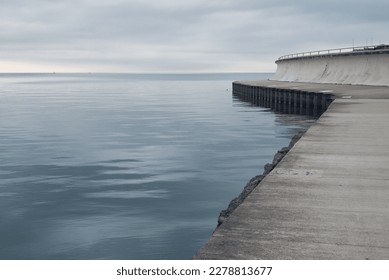 Empty waterfront path on a cloudy day. Peaceful and somber mood.