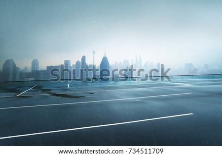 Empty wet asphalt road with foggy city skyline background , raining day .