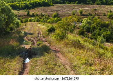 Empty Wet Rural Road In Bad Condition. Mountain Landscape At Sunny Day, Photo Background