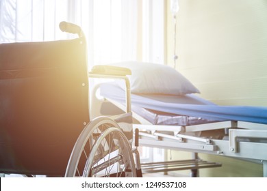 Empty Wheelchair And Hospital Bed Indoors.