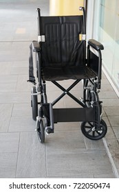 An empty wheelchair next to the clinic window,no patient on wheelchair