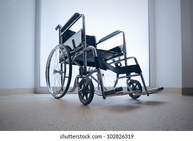 Empty wheelchair parked in hospital hallway - Powered by Shutterstock