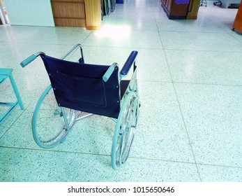 Empty wheelchair resting in the lobby of a hospital. healthcare and disability image - Powered by Shutterstock