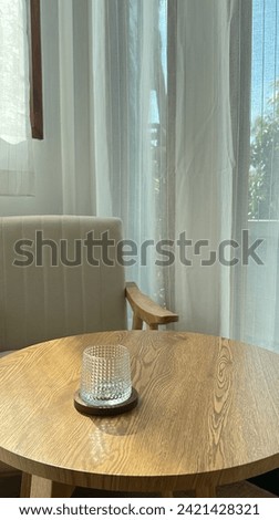 Empty Whiskey or coffee Glasses on Wooden Table with Saucers, Sheer White Curtain Backdrop, and White Chairs in a Café coffee shop