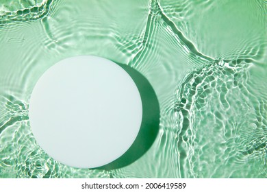 Empty white circle podium on transparent clear green calm water texture with splashes and waves in sunlight. Abstract nature background for product presentation. Flat lay cosmetic mockup, copy space. - Shutterstock ID 2006419589