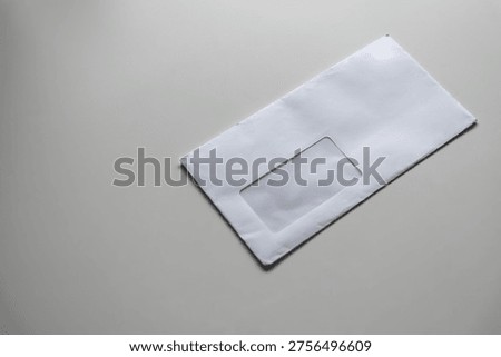 Empty white envelope lying on a table. Minimalist stationery concept, ready for letters, mail, or correspondence. Simple office or home desk setting.