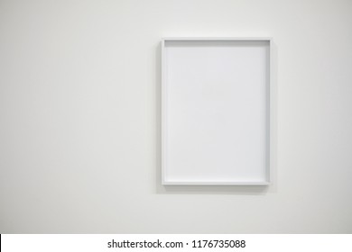 Empty White Frame On White Wall For Interior Decoration. Minimal Concept.