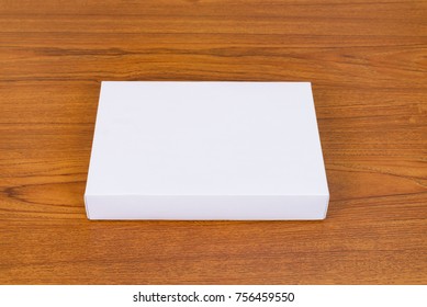 Empty white gift box or tray for mock up on bright wooden table with copy space.