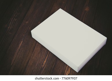 Empty white gift box or tray for mock up on dark wooden table with copy space.