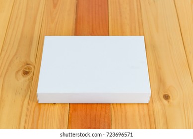 Empty white gift for mock up on bright wooden table with copy space.