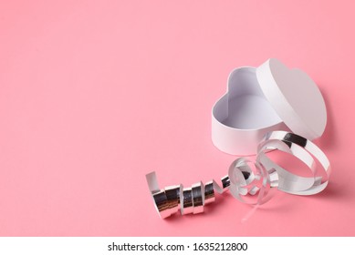 Empty white heart-shaped gift box with a silver ribbon presents or surprises for Valentine's day, international women's day or for celebrating other holidays on a pink background. Copy space.  - Shutterstock ID 1635212800