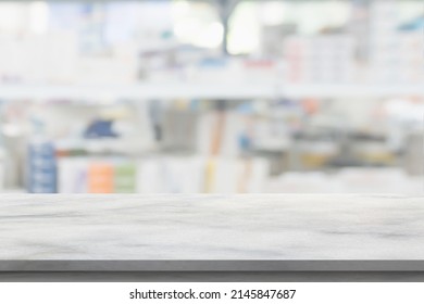 Empty White Marble Counter Top With Blur Pharmacy Drugstore Shelves Background