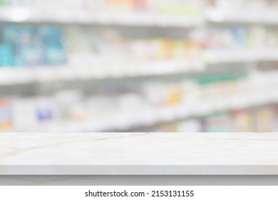 Empty White Marble Counter Top With Blur Pharmacy Drugstore Shelves Background