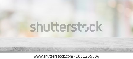 Empty white marble stone table top and blur glass window interior cafe and restaurant banner mock up abstract background - can used for display or montage your products.